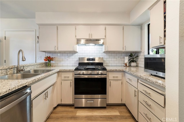 2619 Amanecida, Chico, CA 95928 - kitchen featuring appliances with stainless steel finishes, under cabinet range hood, decorative backsplash, and light wood-type flooring