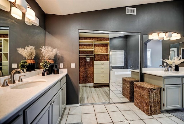 609 Raphael Dr, Corona, CA 92882 - bathroom featuring two vanities, a bath, tile patterned flooring, and vaulted ceiling