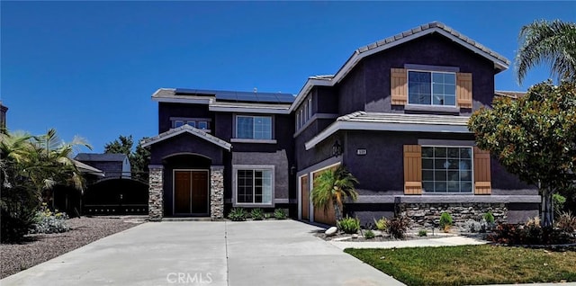 609 Raphael Dr, Corona, CA 92882 - view of front of house featuring roof mounted solar panels, concrete driveway, stucco siding, and stone siding