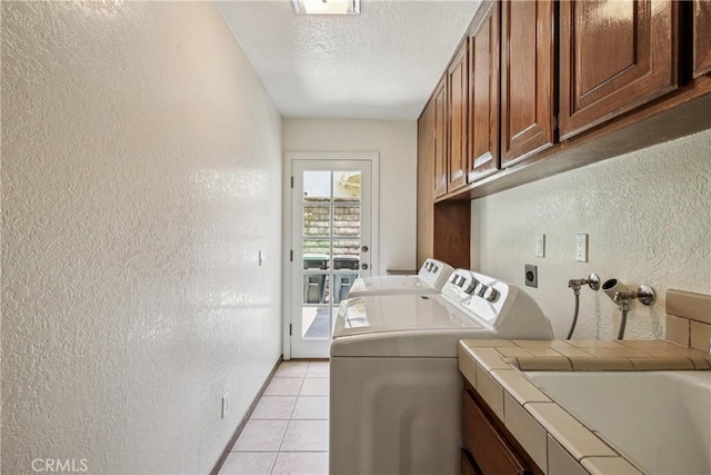 24615 Kings Rd, Laguna Niguel, CA 92677 - washroom with cabinet space, a textured wall, light tile patterned floors, washer and clothes dryer, and a textured ceiling