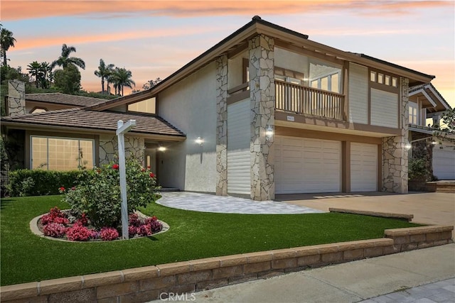 24615 Kings Rd, Laguna Niguel, CA 92677 - view of front of house with a balcony, stucco siding, an attached garage, a yard, and stone siding