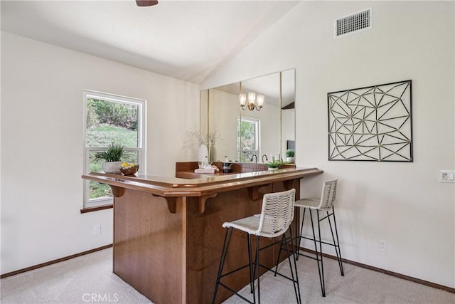 24615 Kings Rd, Laguna Niguel, CA 92677 - kitchen featuring carpet floors, plenty of natural light, lofted ceiling, and a breakfast bar area