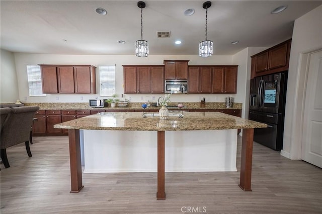 15930 Chorus Ln, Fontana, CA 92336 - kitchen featuring stainless steel microwave, fridge with ice dispenser, light wood finished floors, recessed lighting, and an island with sink