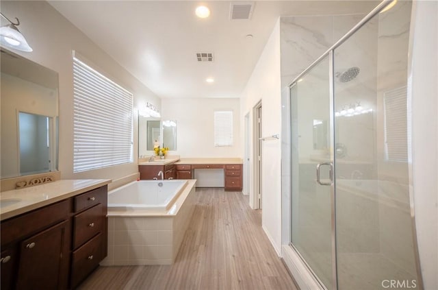 15930 Chorus Ln, Fontana, CA 92336 - full bath with a stall shower, a bath, two vanities, wood finished floors, and recessed lighting