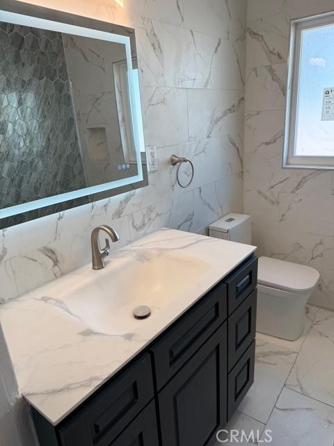 14516 Florita Rd, La Mirada, CA 90638 - bathroom featuring tile walls, vanity, and marble finish floors
