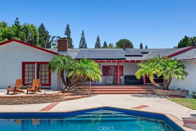10225 Donna Ave, Northridge, CA 91324 - rear view of property with a chimney, a patio, and roof mounted solar panels