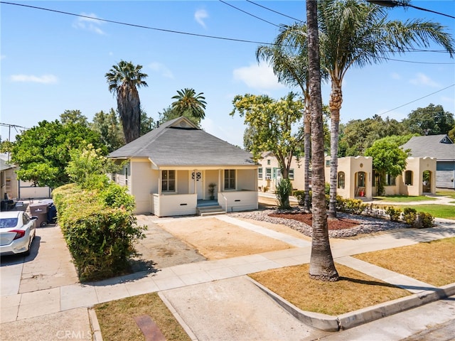 3141 Locust St, Riverside, CA 92501 - view of front facade featuring stucco siding, a porch, and driveway