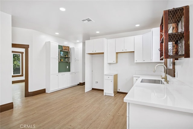 3141 Locust St, Riverside, CA 92501 - kitchen featuring light wood-style flooring, white cabinetry, recessed lighting, and light countertops