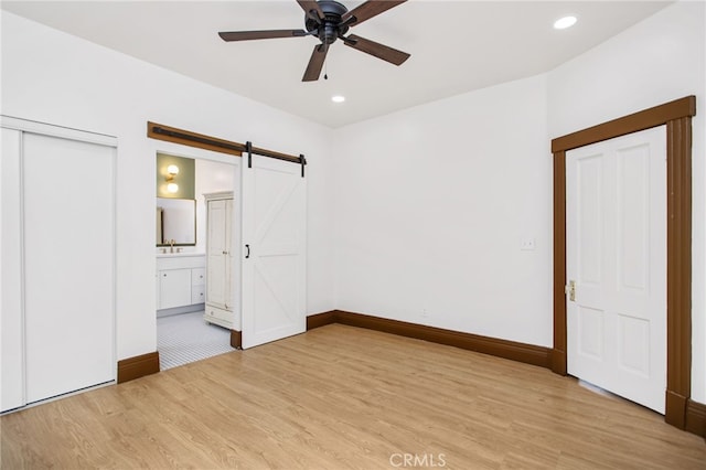 3141 Locust St, Riverside, CA 92501 - unfurnished bedroom with light wood-type flooring, a barn door, recessed lighting, ensuite bath, and a ceiling fan