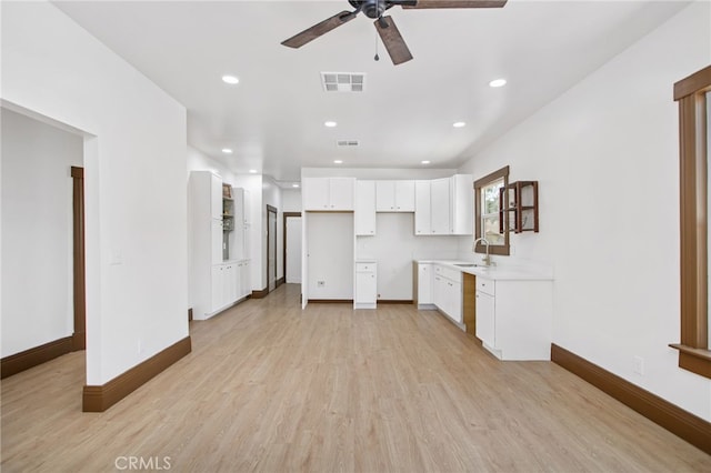 3141 Locust St, Riverside, CA 92501 - kitchen featuring ceiling fan, light wood finished floors, white cabinets, recessed lighting, and light countertops