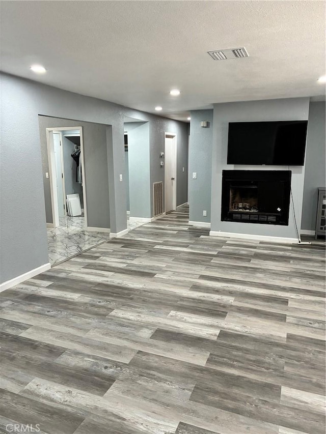 15400 Don Roberto Rd, Victorville, CA 92394 - unfurnished living room with wood finished floors, a textured ceiling, recessed lighting, and a fireplace