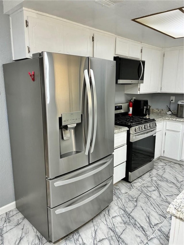 15400 Don Roberto Rd, Victorville, CA 92394 - kitchen featuring appliances with stainless steel finishes, light marble finish floors, white cabinetry, and light stone countertops