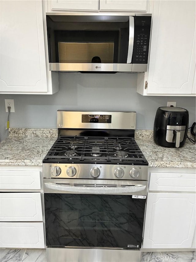 15400 Don Roberto Rd, Victorville, CA 92394 - kitchen with stainless steel appliances, white cabinets, and light stone counters