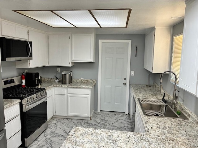 15400 Don Roberto Rd, Victorville, CA 92394 - kitchen featuring black microwave, stainless steel range with gas stovetop, light marble finish floors, and white cabinets