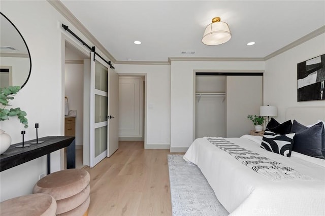 11861 Amethyst St, Garden Grove, CA 92845 - bedroom featuring a barn door, light wood-style flooring, crown molding, a closet, and recessed lighting
