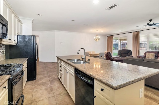 26865 Shelter Cove Ct, Menifee, CA 92585 - kitchen featuring black appliances, a kitchen island with sink, a chandelier, tasteful backsplash, and light stone countertops