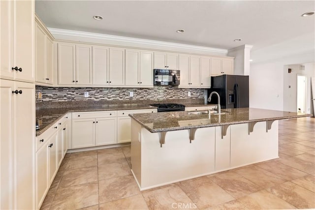 26865 Shelter Cove Ct, Menifee, CA 92585 - kitchen featuring black appliances, decorative backsplash, a kitchen bar, a center island with sink, and dark stone countertops
