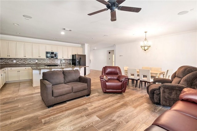 26865 Shelter Cove Ct, Menifee, CA 92585 - living area with ornamental molding, a ceiling fan, light wood-style floors, a chandelier, and recessed lighting