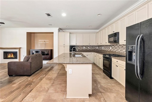 26865 Shelter Cove Ct, Menifee, CA 92585 - kitchen with black appliances, open floor plan, crown molding, decorative backsplash, and a glass covered fireplace