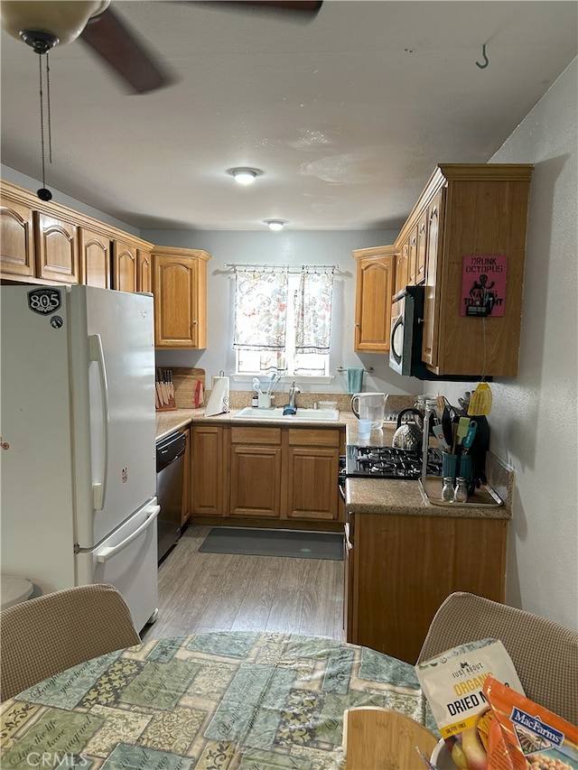 826 Railroad St, Corona, CA 92882 - kitchen featuring stainless steel appliances, light wood-style floors, ceiling fan, and brown cabinetry
