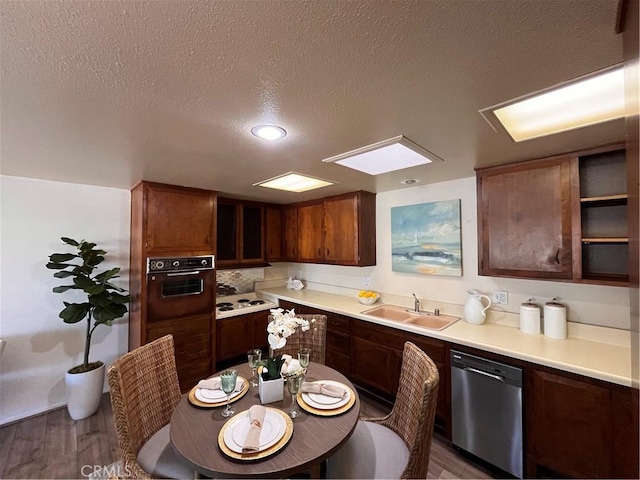 13821 Fresh Meadow Ln Unit M3-D, Seal Beach, CA 90740 - kitchen featuring stainless steel dishwasher, wall oven, a textured ceiling, light countertops, and wood finished floors