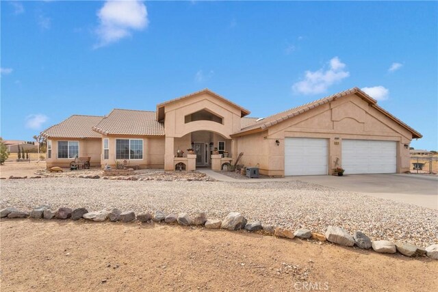10776 Joshua St, Oak Hills, CA 92344 - mediterranean / spanish-style house featuring a tile roof, an attached garage, stucco siding, and concrete driveway