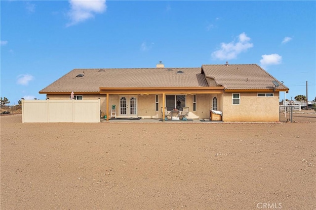 10776 Joshua St, Oak Hills, CA 92344 - back of property featuring a tiled roof, a patio, stucco siding, and a chimney