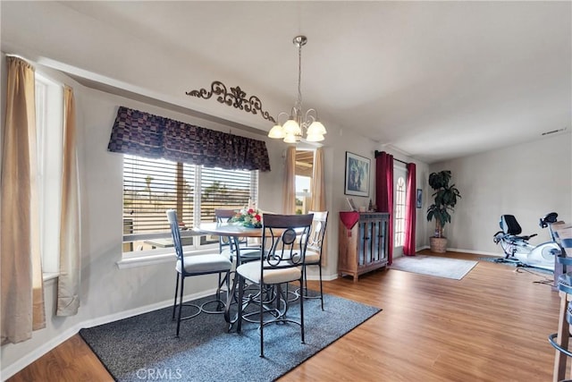 10776 Joshua St, Oak Hills, CA 92344 - dining area featuring a chandelier and wood finished floors