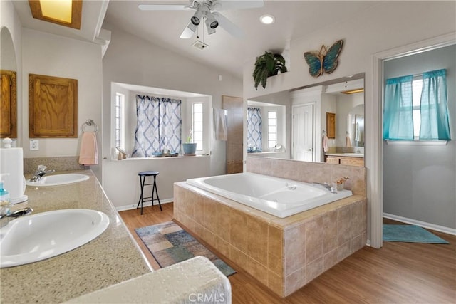 10776 Joshua St, Oak Hills, CA 92344 - full bathroom featuring a bath, double vanity, wood finished floors, a ceiling fan, and vaulted ceiling
