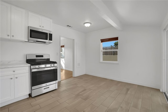 3032 Cogswell Rd, El Monte, CA 91732 - kitchen featuring stainless steel appliances, light wood finished floors, white cabinets, beamed ceiling, and light stone countertops