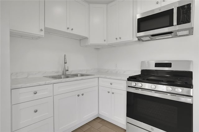 3032 Cogswell Rd, El Monte, CA 91732 - kitchen with appliances with stainless steel finishes, white cabinetry, and light stone countertops