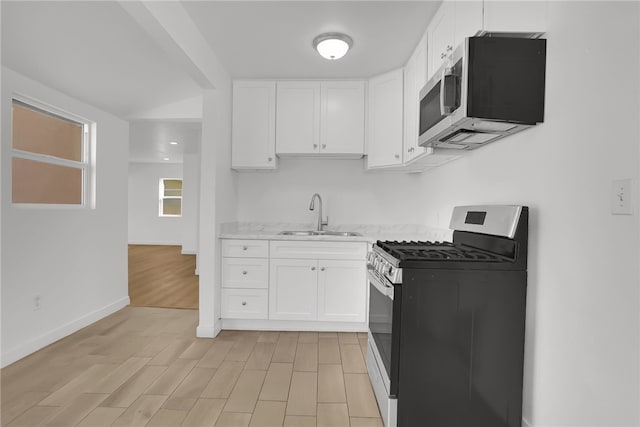 3032 Cogswell Rd, El Monte, CA 91732 - kitchen with appliances with stainless steel finishes, white cabinets, light stone countertops, and light wood-style floors