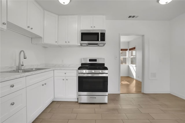 3032 Cogswell Rd, El Monte, CA 91732 - kitchen featuring stainless steel appliances, white cabinets, and light stone countertops