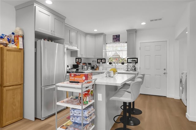 3032 Cogswell Rd, El Monte, CA 91732 - kitchen featuring freestanding refrigerator, light wood finished floors, light countertops, recessed lighting, and a kitchen bar