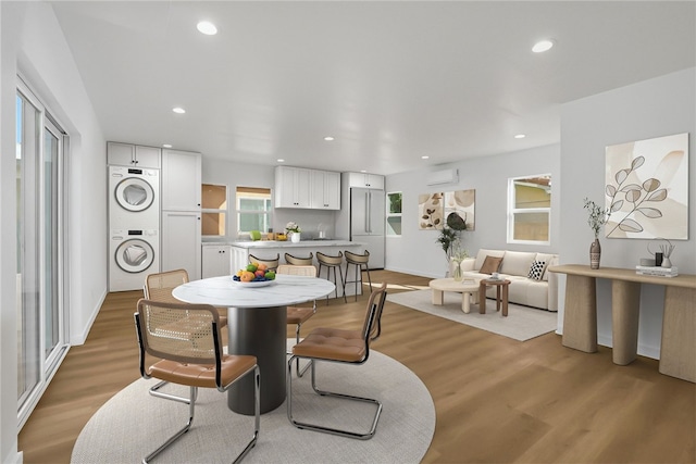 3032 Cogswell Rd, El Monte, CA 91732 - dining space with stacked washing machine and dryer, an AC wall unit, light wood-style floors, and recessed lighting