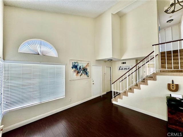 11308 Sherwood Ct, Fontana, CA 92337 - entrance foyer featuring stairway, wood finished floors, a towering ceiling, and a textured ceiling