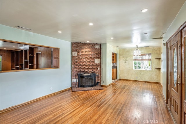 7134 Stansbury Ave, Van Nuys, CA 91405 - unfurnished living room featuring light wood finished floors, a brick fireplace, recessed lighting, and a chandelier