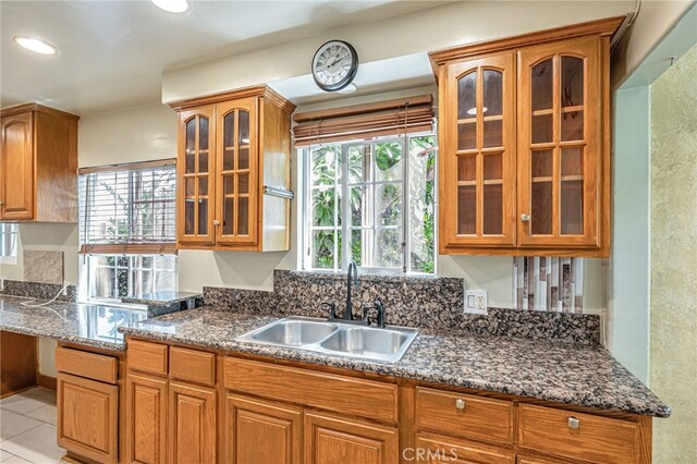 7134 Stansbury Ave, Van Nuys, CA 91405 - kitchen featuring glass insert cabinets, brown cabinets, dark stone countertops, and recessed lighting