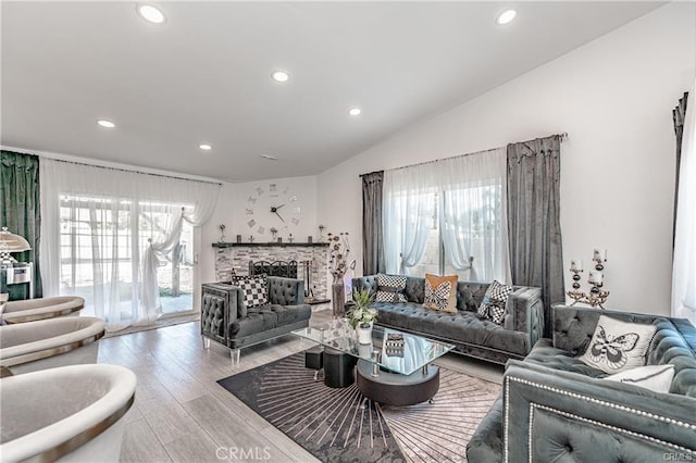 13800 Glenoaks Blvd, Sylmar, CA 91342 - living room featuring recessed lighting, healthy amount of natural light, wood finished floors, lofted ceiling, and a fireplace with raised hearth