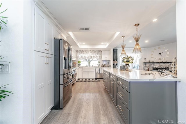 13800 Glenoaks Blvd, Sylmar, CA 91342 - kitchen with appliances with stainless steel finishes, a raised ceiling, light wood-style floors, gray cabinetry, and white cabinets