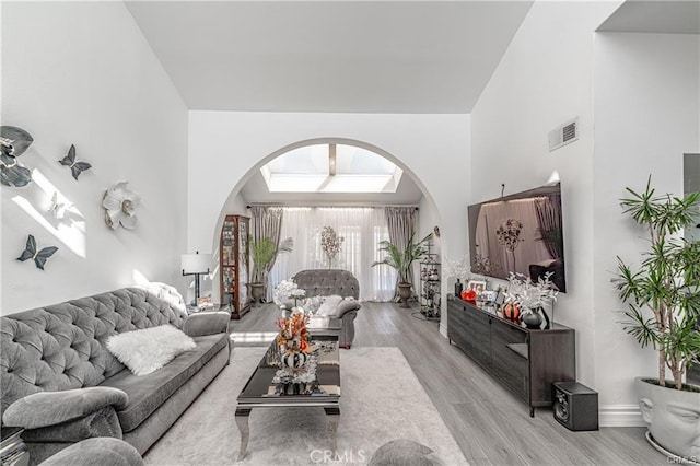13800 Glenoaks Blvd, Sylmar, CA 91342 - living room with arched walkways, light wood finished floors, and a high ceiling
