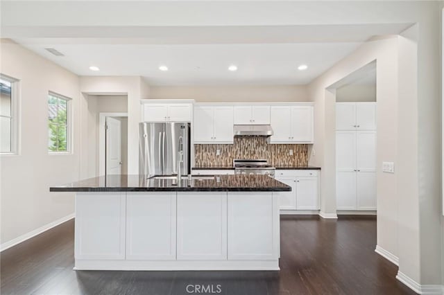 72 Peony, Irvine, CA 92618 - kitchen with under cabinet range hood, stove, freestanding refrigerator, and dark wood-style floors