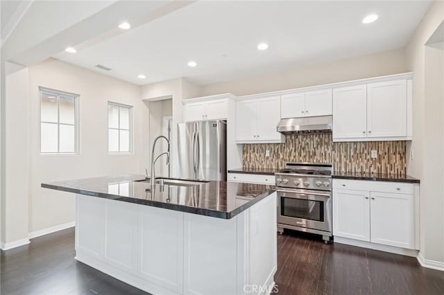 72 Peony, Irvine, CA 92618 - kitchen with appliances with stainless steel finishes, under cabinet range hood, tasteful backsplash, an island with sink, and white cabinets