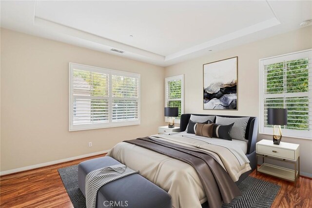 72 Peony, Irvine, CA 92618 - bedroom featuring a raised ceiling, wood finished floors, and multiple windows