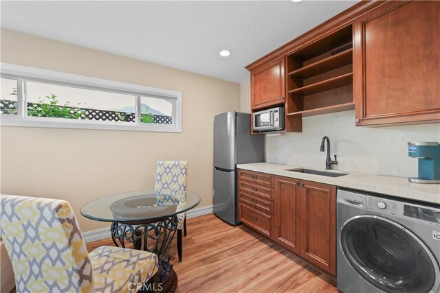 5706 E Bryce Ave, Orange, CA 92867 - kitchen featuring washer / dryer, open shelves, stainless steel appliances, light countertops, and light wood-style floors