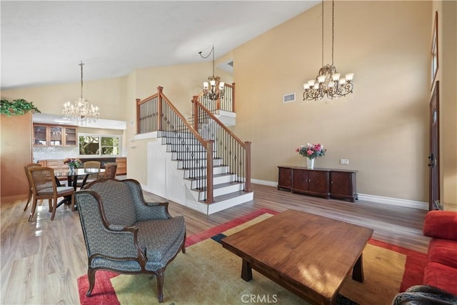 5706 E Bryce Ave, Orange, CA 92867 - living area featuring a chandelier, high vaulted ceiling, wood finished floors, and stairway