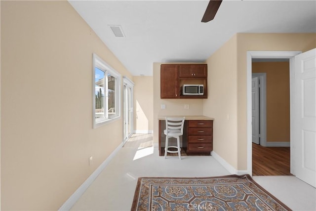 5706 E Bryce Ave, Orange, CA 92867 - kitchen with stainless steel microwave, ceiling fan, light countertops, and built in study area