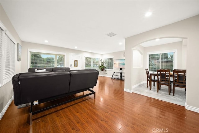 12077 Conference St, El Monte, CA 91732 - living room with arched walkways, wood finished floors, recessed lighting, and plenty of natural light