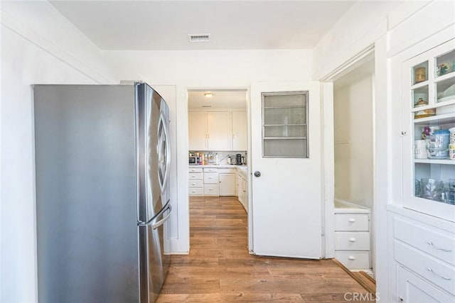 201 S Spruce St, Montebello, CA 90640 - kitchen featuring freestanding refrigerator, white cabinets, wood finished floors, and light countertops