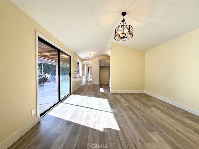 1639 Winn Ct, Pomona, CA 91768 - unfurnished dining area featuring a chandelier, wood finished floors, and vaulted ceiling